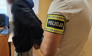Zdjęcie przedstawia zatrzymanego z policjantem kryminalnym.
