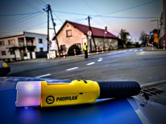 Zdjęcie przedstawia alkomat na masce radiowozu.