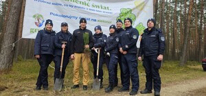 Zdjęcie przedstawia wydarzenie związane z jubileuszem 100-lecia dzielnicowych, którzy z tej okazji posadzili symboliczne 100 sadzonek w lesie.
