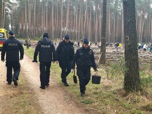 Zdjęcie przedstawia wydarzenie związane z jubileuszem 100-lecia dzielnicowych, którzy z tej okazji posadzili symboliczne 100 sadzonek w lesie.