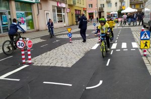 dzieci jeżdżą na rowerach po trasie miasteczka ruchu drogowego