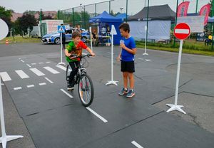 dzieci jeżdżą rowerem po miasteczku ruchu drogowego