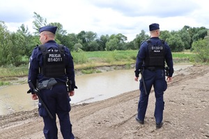 Zdjęcie: policjanci kontrolują stan wody.