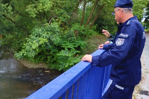Zdjęcie: policjanci kontrolują stan wody.