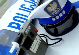 urządzenie do pomiaru alkoholu w wydychanym powietrzu,czapka policjanta ruchu drogowego i belka z sygnałami radiowozu