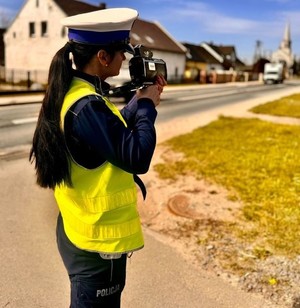 policjanta trzymająca miernik prędkości