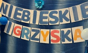 Na obrazku znajduje się napis &quot;Niebieskie Igrzyska&quot;.