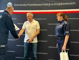 Fotografie przedstawiają Komendanta Powiatowego Policji w Krapkowicach oraz I Zastępcę, którzy wręczają gratulacje Panu Henrykowi, który odnalazł zaginionego 73-latka.