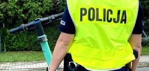na zdjęciu znajduje się policjant który stoi obok hulajnogi elektrycznej