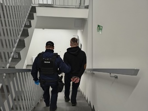 widoczni dwaj mężczyźni idący po schodach w dół