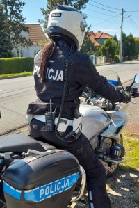 policjantka na motocyklu policyjnym, w tle jezdnia i zabudowania