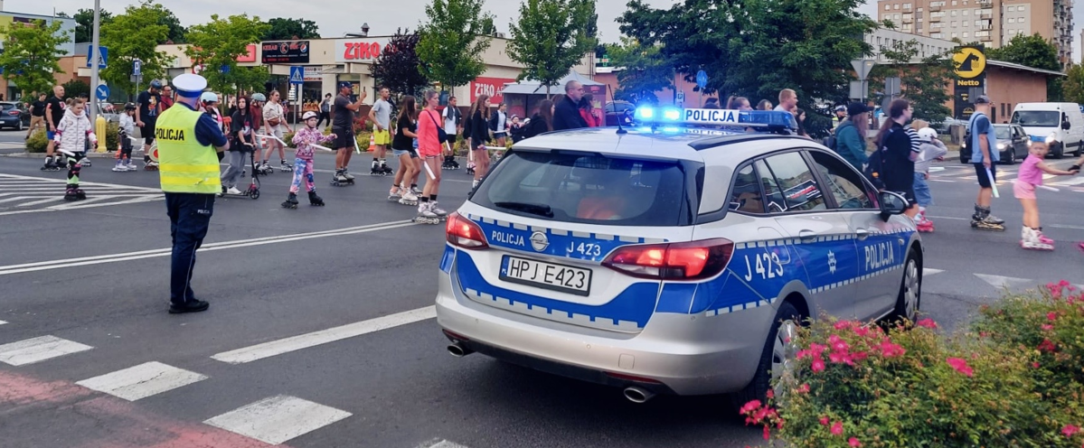 zdjęcie: policjant ruchu drogowego zabezpieczający przejazd rolkarzy