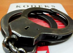 Grafika przedstawia kodeks na którym leżą kajdanki