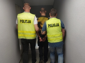 Policjanci prowadzą zatrzymanego