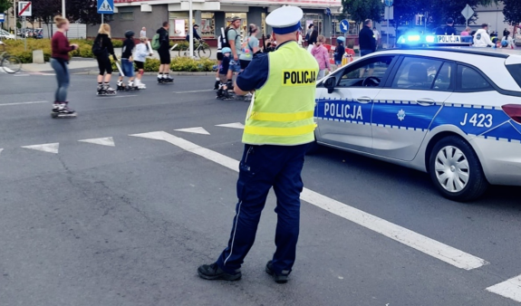 zdjęcie: policjant ruchu drogowego zabezpieczający przejazd rolkarzy