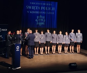 zdjęcie kolorowe - przedstawiające sylwetki funkcjonariuszy na scenie