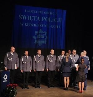 zdjęcie kolorowe - przedstawiające sylwetki funkcjonariuszy na scenie