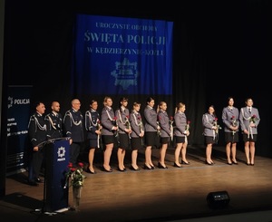 zdjęcie kolorowe - przedstawiające sylwetki funkcjonariuszy na scenie