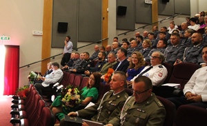 zdjęcie kolorowe - przedstawiające sylwetki funkcjonariuszy na scenie