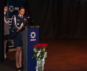 zdjęcie kolorowe - przedstawiające sylwetki funkcjonariuszy na scenie