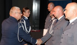 zdjęcie kolorowe - przedstawiające sylwetki funkcjonariuszy na scenie