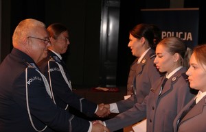 zdjęcie kolorowe - przedstawiające sylwetki funkcjonariuszy na scenie