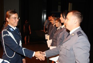 zdjęcie kolorowe - przedstawiające sylwetki funkcjonariuszy na scenie