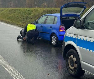policjanci pomagający kierowcy w potrzebie