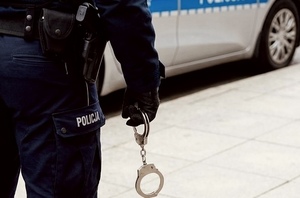 funkcjonariusz policji trzymający kajdanki