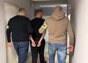 zatrzymany sprawca rozboju prowadzony przez funkcjonariuszy policji