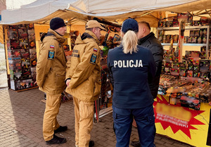 funkcjonariusze policji i strażacy kontrolujący punkty sprzedaży fajerwerków.