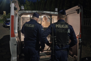 funkcjonariusze z zatrzymanym poszukiwanym