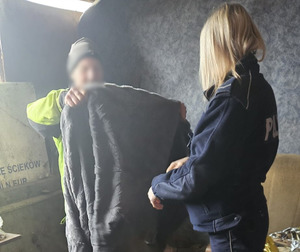 dzielnicowi pomagający bezdomnemu mężczyźnie