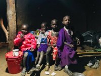 Dzieci z Tanzanii siedzą w oświetlonym domu