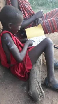 Dziecko z Tanzanii siedzi i czyta książkę