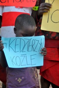 Chłopiec z Tanzanii trzyma w ręce kartkę z napisem in Kędzierzyn-Koźle
