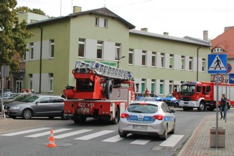 radiowozy policyjne i wozy straży pożarnej stoją zaparkowane przy budynku szpitala