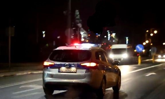 Radiowóz nocą jedzie ulicami miasta