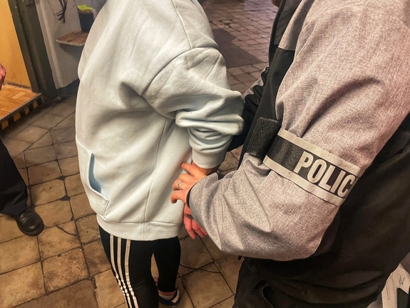 zatrzymana kobieta prowadzona przez policjantów