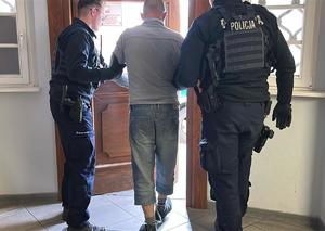 prowadzony przez policjantów zatrzymany mężczyzna