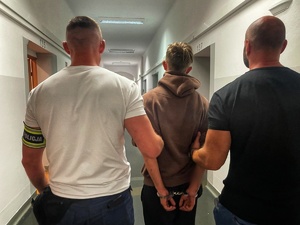 policjanci prowadzą zatrzymanego