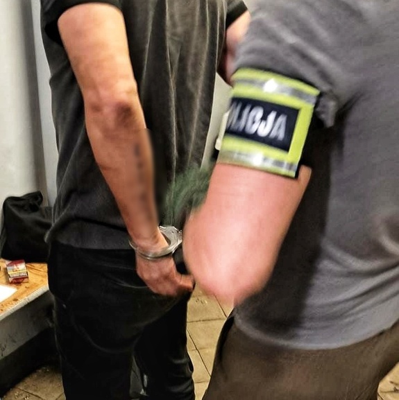 policjanci trzymają zatrzymanego