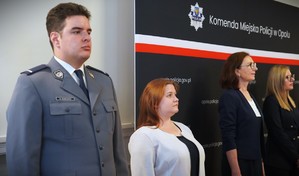 Policjant i kobiety stojące w szeregu.
