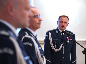 Zdjęcie: policjant przemawia do mikrofonu.