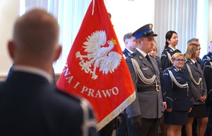Zdjęcie: policjanci stoją obok sztandaru.