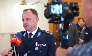 Zdjęcie: policjant wypowiada się do mikrofonu.