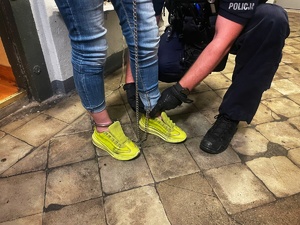 policjanci prowadzą zatrzymaną kobietę