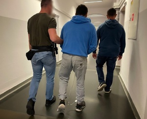 policjanci prowadzą zatrzymanego