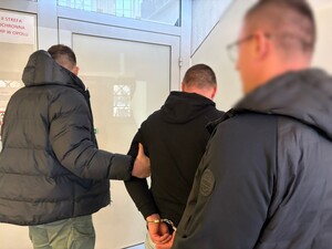 policjanci prowadzą zatrzymanego