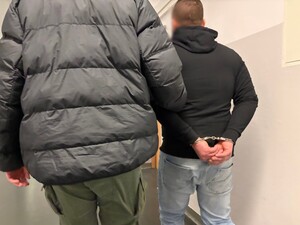 policjanci prowadza zatrzymanego